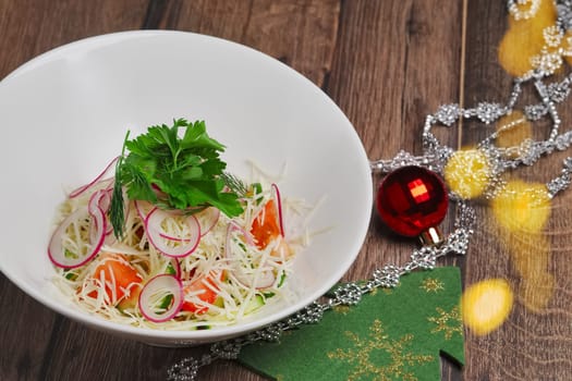 Christmas salad with radish, tomato, cucumber and cheese on wooden table