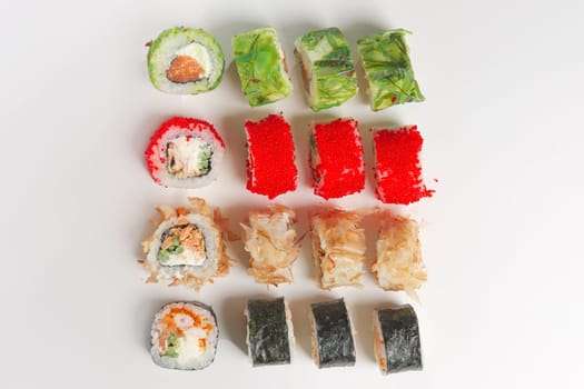 Set of rolls with smoked salmon, eel, chukka salad and flying fish roe on white background. Top view.