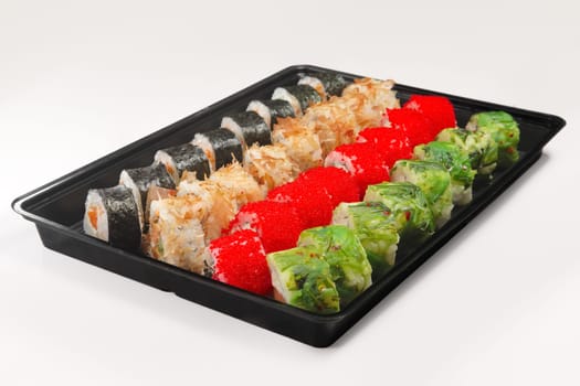 Plastic tray with set of rolls with smoked salmon, eel, chuka salad and flying fish roe on white background.