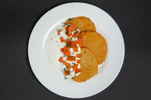 Top view of traditional belorussian potato pancakes with salmon and sour cream