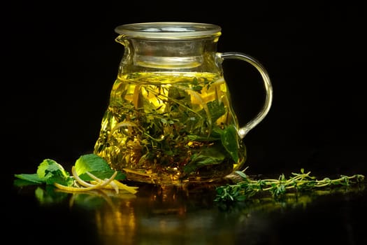 Pot with fruit tea on black background. (soft focus photo)