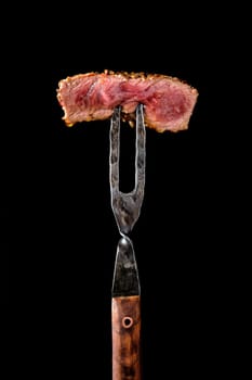 Piece of medium rare steak on the fork