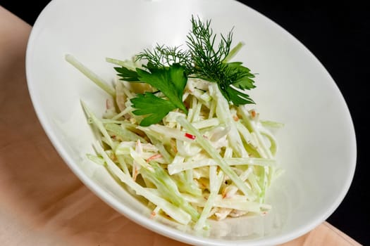 Plate with salad with crab, cucumber and cabbage cutted in straws