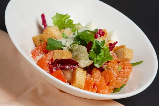 Plate with salmon, tomato and egg salad on white background