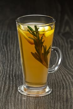 Glass of hot fruit tea on wooden table (soft focus photo)