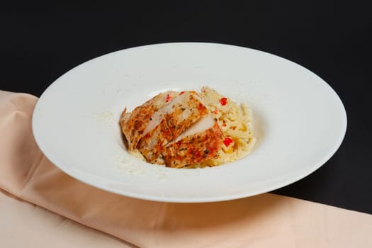 plate with pasta, cheese and chicken fillet