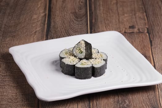 roll with cucumber and sesame on square plate