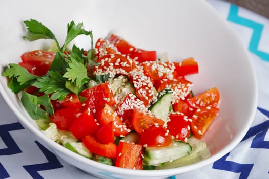 salad with fresh cucumber, tomato, bell pepper, cabbage and sesame