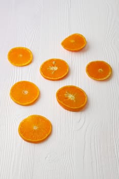 Orange slices on white rustic wooden background, top view, flat lay