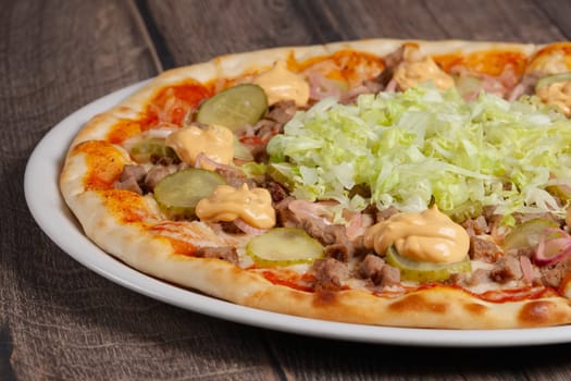 part of pizza with meat and vegetables on wooden table