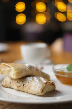 Soft focus photo of pancakes with jam and cup of coffee. Breakfast at a cafe