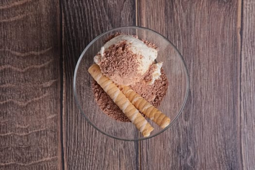 ice cream with chocolate and cookie in glass on wooden table. Top view.