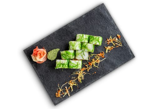 Set of rolls with wasabi and pickled ginger on stone serving board isolated on white