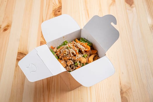 Udon noodles with chicken, green bean, bell pepper and sesame  in take away box