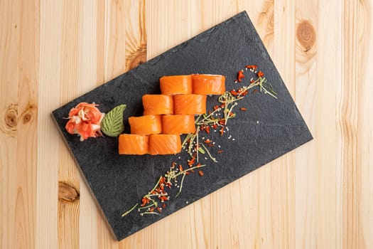 Set of rolls with wasabi and pickled ginger on stone serving board