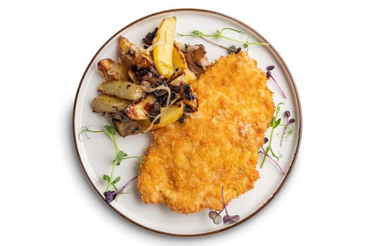Tasty schnitzel in breading with fried potato, onion and mushrooms