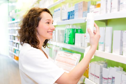 VIew of an Attractive pharmacist clean the store up
