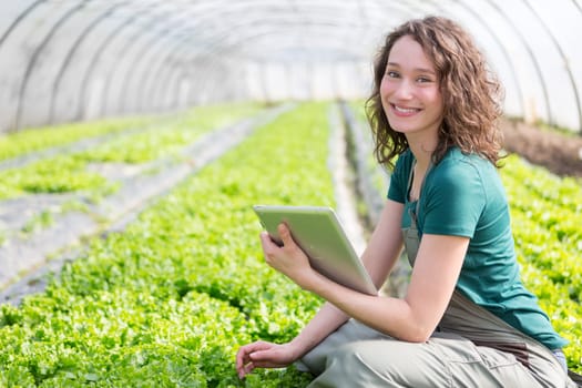 View of an attractive farmer in a greenhouse using tablet