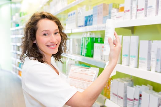 VIew of an Attractive pharmacist clean the store up