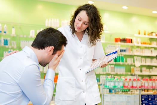 View of an Attractive pharmacist comfort a customer suffering