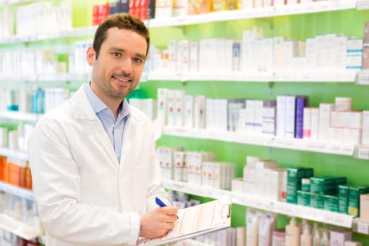 Vjew of a Attractive pharmacist taking notes at work