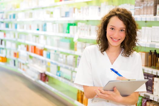View of an Attractive pharmacist taking notes at work