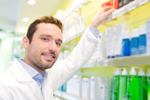 View of an Attractive pharmacist clean the store up