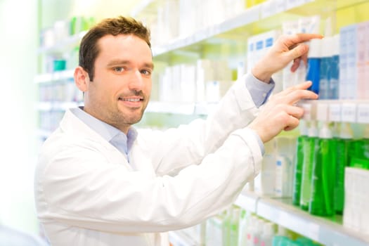 View of an Attractive pharmacist clean the store up