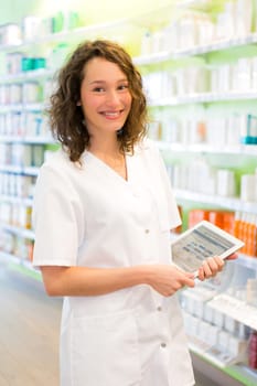 VIew of an Attractive pharmacist using tablet at work