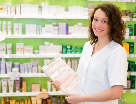 View of an Attractive pharmacist taking notes at work