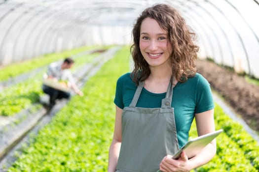View of an attractive farmer in a greenhouse using tablet