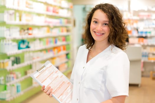 View of an Attractive pharmacist taking notes at work