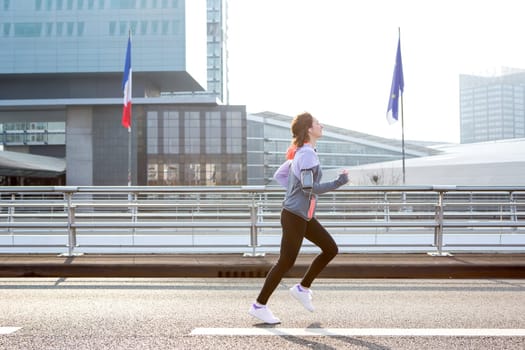 View of a Young attractive woman running downtown