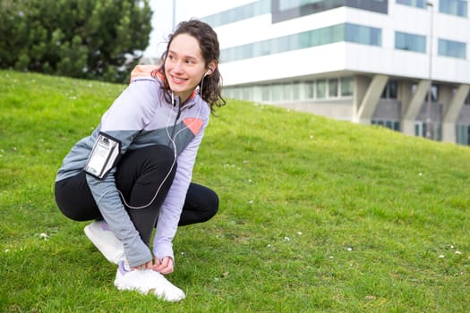 View of a Young attractive woman tying shoelaces before a running session