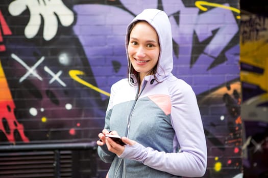 View of a Young attractive woman adjust her music player before running