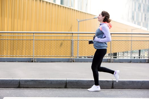 View of a Young attractive woman running downtown