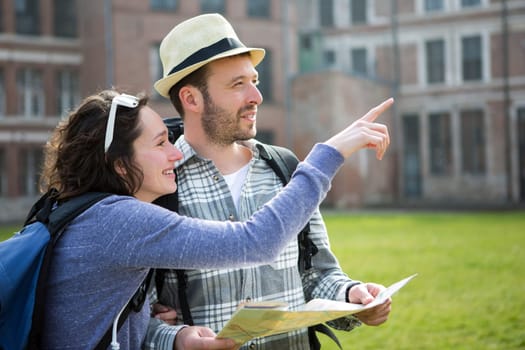 View of a Couple of young attractive tourists watching map