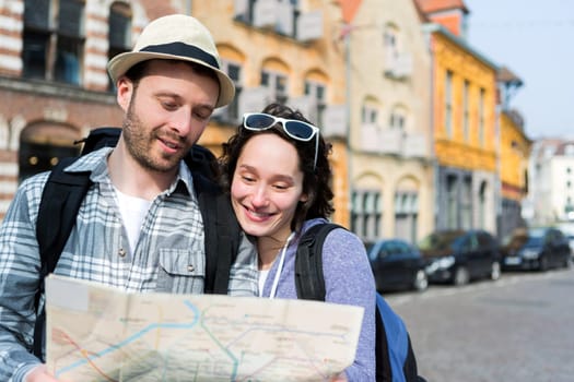 View of a Couple of young attractive tourists watching map
