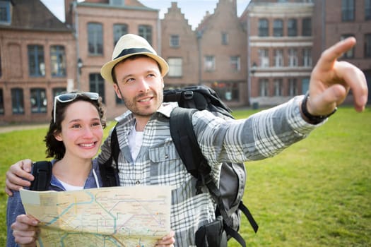 View of a Couple of young attractive tourists watching map