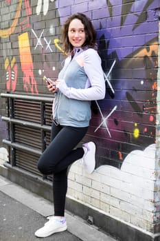 View of a Young attractive woman adjust her music player before running
