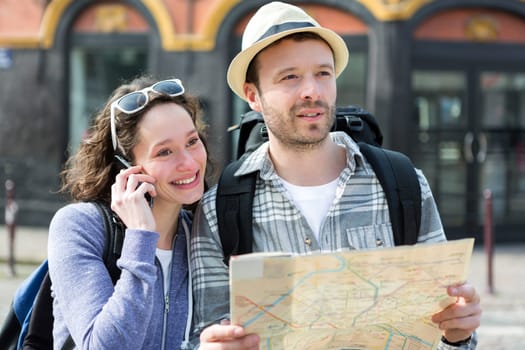 View of a Couple of young attractive tourists watching map