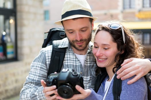 View of Young couple of tourist watching photographs on camera