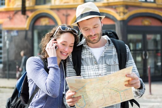 View of a Couple of young attractive tourists watching map