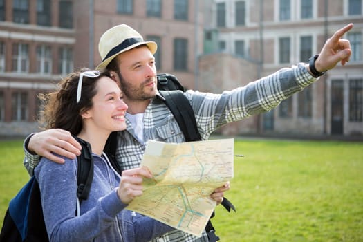 View of a Couple of young attractive tourists watching map