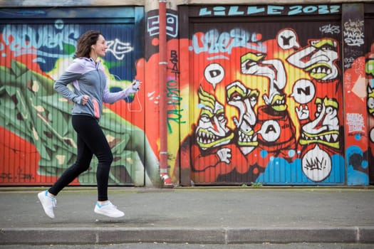 View of a Young attractive woman running downtown