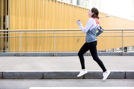 View of a Young attractive woman running downtown