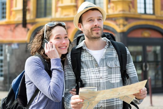 View of a Couple of young attractive tourists watching map