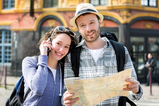 View of a Couple of young attractive tourists watching map