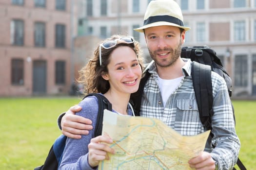 View of a Couple of young attractive tourists watching map