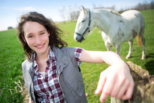 View of a young attractive farmer in fields with horse